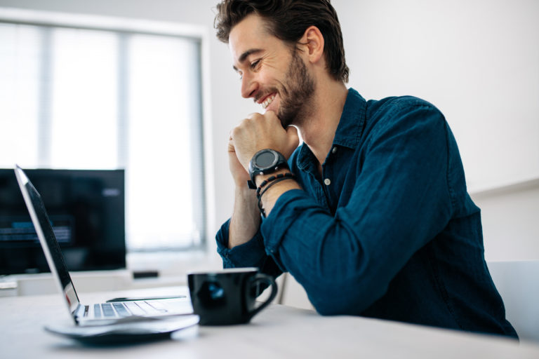 Mann am Schreibtisch freut sich über Single Sign-On